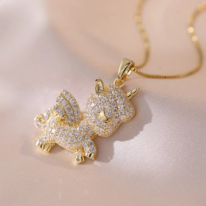 Golden unicorn pendant necklace with sparkling cubic zirconia on pink silk background