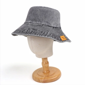 Dettaglio del cappello alla pescatora in denim lavato vintage con toppa arancione