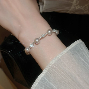 Vue détaillée d'un bracelet en perles avec billes argentées sur un poignet féminin