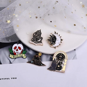Gothic Halloween enamel pins with skull and mystic star moon designs on white lace display