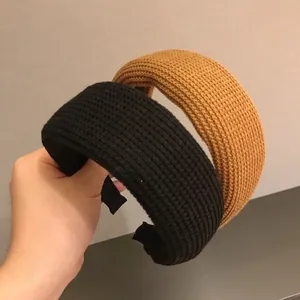 Detail view of wide knitted headbands in black and yellow showing waffle texture