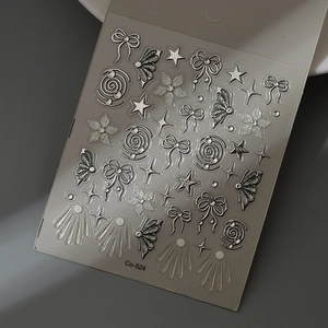 Macro shot of silver 3D bow and butterfly nail art stickers with metallic glitter details