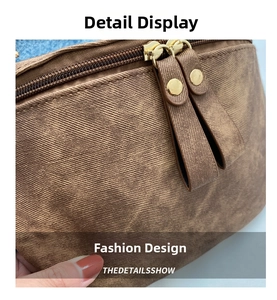 Détail du sac en sergé marron avec double fermeture éclair dorée et rivets décoratifs