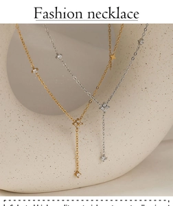 Detail of gold and silver Y-shaped necklaces with zircon clover charms on ceramic props