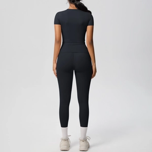Rear view of black high-stretch two-piece athletic yoga set with short sleeve top and leggings
