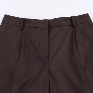 Vue détaillée du pantalon marron foncé avec passants de ceinture et couture braguette