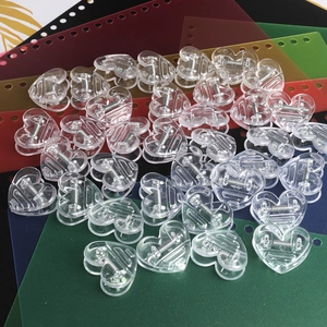 Macro shot of transparent heart-shaped plastic clips with metal springs for paper organizing
