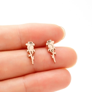 Macro detail of rose gold rose-shaped studs with intricate petal and leaf textures