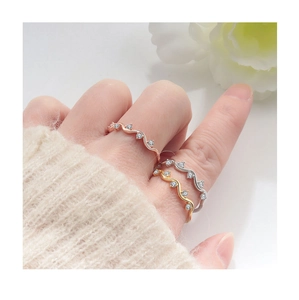 Detailed view of wave-shaped S925 silver rings set with zircon in gold and rose gold