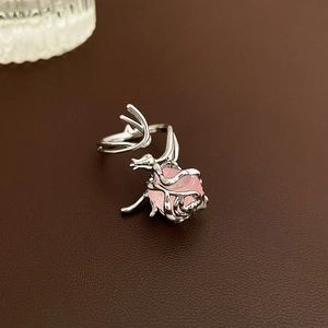 Macro detail of silver rose ring with pink zircon on dark brown leather background