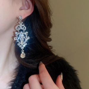 Detail shot of elegant baroque drop earrings featuring clear crystals and teardrop pendant