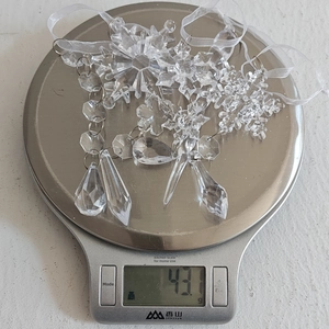 Detailed view of clear acrylic Christmas ornaments set showing weight of 43.1g on a scale