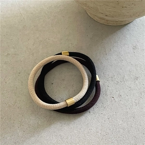 Detailed shot of elastic hair bands in milk coffee tones with golden metal buckles