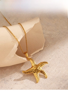 Detail of golden starfish pendant with hammer-textured finish on minimalist chain