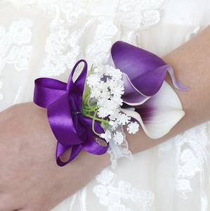Detail of bridal wrist corsage with purple calla lilies, white lace band and satin ribbon