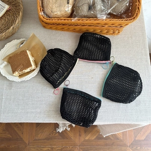 Set van vier mesh portemonnees met kleurrijke ritsen op een linnen tafelkleed