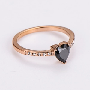 Detail of a heart-shaped black gemstone ring in rose gold with white side stones