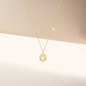 Detail of s925 silver gold chain with white shell flower pendant and zircon stone