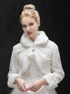 Detail of white faux fur bridal shawl with wavy texture, stand collar, and pompom ties