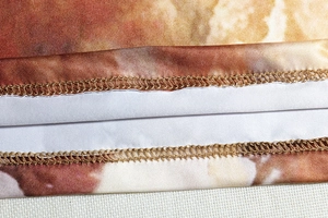 Détail de couture renforcée à double aiguille sur robe en maille à motif abstrait