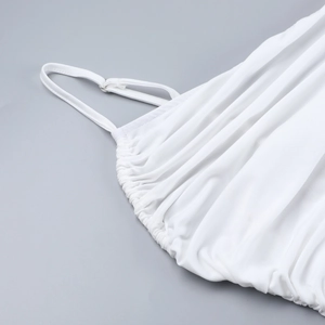 Vue détaillée de la robe blanche montrant les fines bretelles et le décolleté plissé