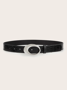 Detail of black crocodile embossed leather belt with a minimalist silver oval buckle