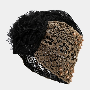 Makro-Detail von Bronze-Spitze und handgenähten Perlen auf diesem Turban-Hut