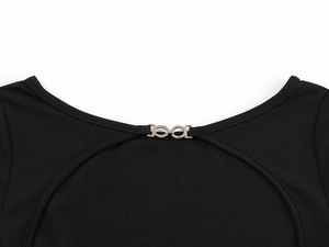 Détail du t-shirt à épaules dénudées avec boucle métallique et texture de maille noire