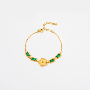 Detail of gold floral bracelet with green emerald zircons and lobster clasp closure