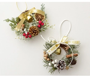 Close-up of mini Christmas wreaths with pine cones, red berries, and festive gold bells
