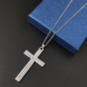 Minimalist silver cross necklace pendant on a slim metal chain with blue gift box