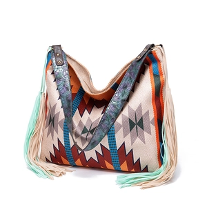 Close-up of bohemian woven tote bag with fringe details and embossed floral leather strap