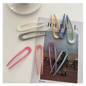 U-shaped hair pins in colorful matte finish displayed on a magazine background