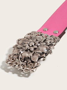 Detail of pink leather belt featuring an intricate silver floral buckle and hollow design