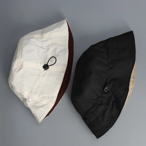 Detailed texture of reversible linen sun hat with adjustable drawstring and toggle