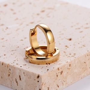Minimalist polished gold stainless steel hoop earrings on natural stone background