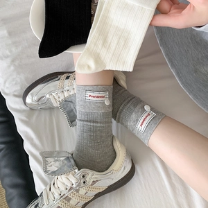 Grey ribbed mid-calf cotton socks with red woven label and decorative button details