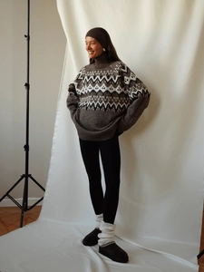 Detail of loose-fit Fair Isle knit sweater featuring geometric patterns and high collar