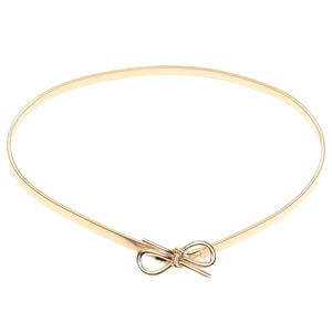 Detailed close-up of a golden spring elastic waist belt with a bow-shaped metal buckle