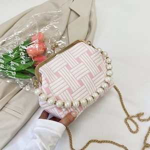 Detail of pink and white woven shell bag featuring a pearl handle and gold metal chain