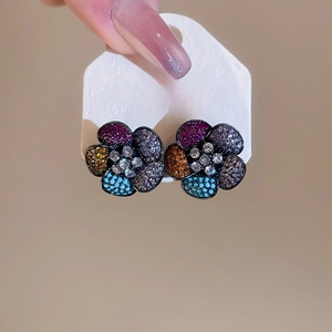 Macro detail of S925 silver flower earrings with colorful sparkling zircon petals