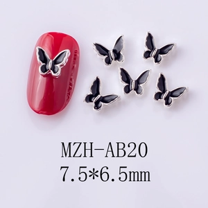 Macro detail of 7.5x6.5mm black drip oil butterfly nail charms with silver metal edges