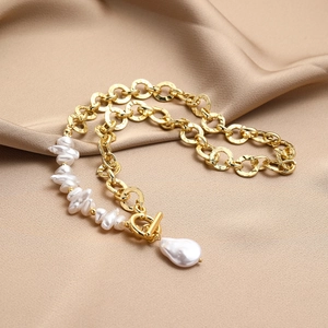 Detail of baroque pearl necklace with golden chain and OT toggle clasp on satin