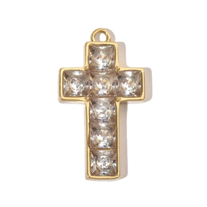 Macro shot of a gold-plated stainless steel cross pendant featuring square clear gemstones