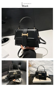 Close-up of black synthetic leather handbag featuring a golden H-shaped metal buckle