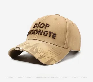 Detail of 3D embroidery and distressed ripped brim on a khaki street style baseball cap
