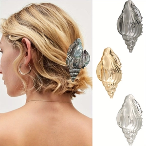 Detail view of metallic shell hair clips in gold and silver finish for beach styling