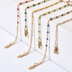 Detail of colorful beads on stainless steel gold bracelets with lobster clasp and chain