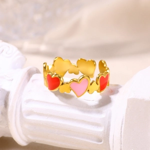 Macro detail of 18K gold-plated enamel ring with red and pink hearts on a pedestal