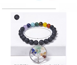 Detail view of 8mm chakra bracelet with black lava stones and tree of life charm